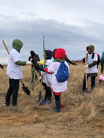 Children planting trees outside. 