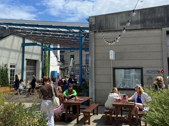 Several people are having coffee at the terrace of a bar