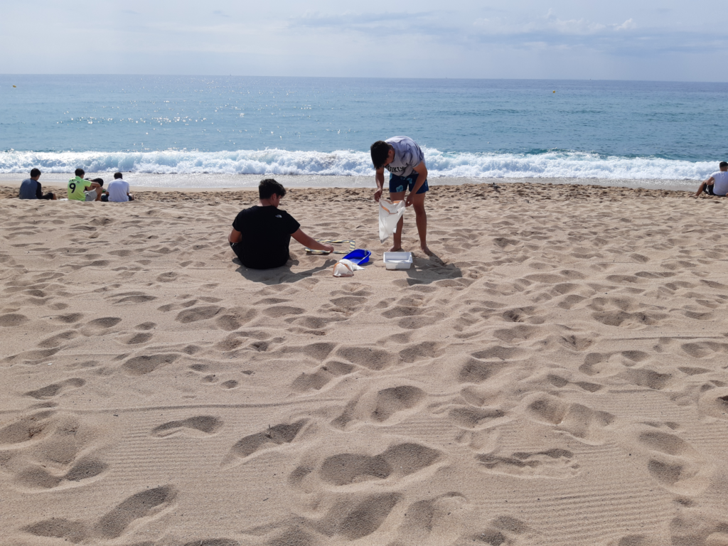 Two students are looking for microplastic at the beach.